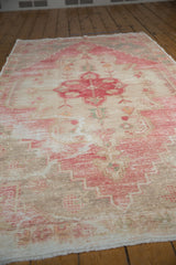 Distressed cherry red and ivory geometric floral motifs with visible foundation on a vintage Oushak rug.