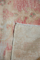 Vintage Distressed Oushak rug corner showing worn pale red pile and hand-knotted foundation.