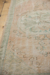 Distressed vintage Oushak runner edge, faded dusty rose field, sea foam green selvage.