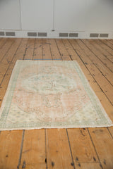 Oushak runner detail: faded dusty rose and sea foam green pile with even wear.