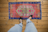 Hand-knotted Oushak rug with distressed pink field, royal blue border, and even wear.