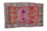 Distressed vintage Oushak rug mat with bursting pink, fuchsia, and beige floral bouquet.