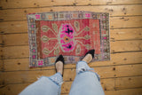 Distressed Oushak rug mat with worn pink, fuchsia, beige pile and faint foundation showing.