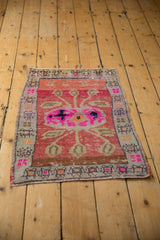 Distressed Oushak rug texture with vibrant pink floral motifs and abrashed field.