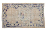 Distressed vintage Oushak rug, antique ivory field, navy blue motifs, faded rose medallion.