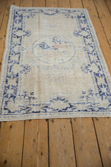 Faded navy blue border and fringe detail on a vintage Oushak rug.