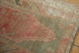 Textured vintage Oushak rug pile with dusty raspberry, seafoam, and ivory hues.