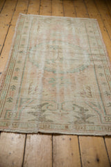 Distressed Oushak runner texture with geometric border, blush, beige, mint blue tones, showing wear.