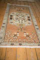 Distressed vintage Oushak runner, showing copper floral motifs, slate blue border, and even wear.