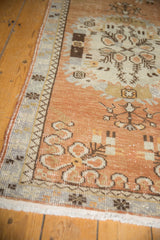 Worn copper and ivory floral motifs with slate blue border on a vintage Oushak runner.