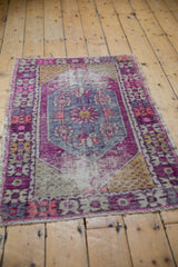 Distressed vintage Oushak rug showing faded hues, central medallion, and even wear.