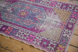 Distressed texture of vintage Oushak rug showing plum, pink, and ivory wear.