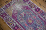 Detailed view of faded royal blue and plum floral motifs with visible distressed knot heads.