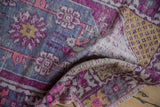 Distressed Oushak rug close-up, highlighting low pile, violet and pink patterns, saffron yellow motif.