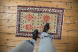 Distressed Oushak rug features warm caramel field, brick red starbursts, and navy geometric accents.