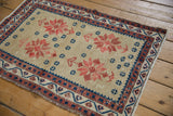 Distressed Oushak rug detail, caramel field, brick red starburst floral, navy blue geometric border.