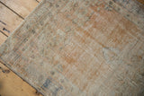 Distressed Oushak rug pile, showing worn texture and muted apricot, ivory, slate blue.