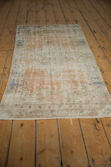 Distressed Oushak rug pile texture showing wear to foundation, muted apricot and slate blue.
