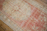 Close-up of the distressed Oushak runner, highlighting faded dusty raspberry and visible foundation.