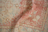 Distressed Oushak rug runner texture, showing faded cherry red, blush, and ivory pile.