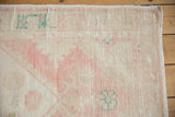 Distressed texture and faded pink, beige, and teal hues on vintage Oushak rug runner.