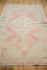 Distressed Oushak runner's worn texture with faded pink, ivory, beige, and subtle teal pile.