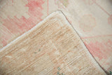 Distressed vintage Oushak runner's hand-knotted back and faded pink and beige pile.