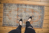 Apricot and faded blue distressed Oushak rug with decorative worn pile and floral motifs underfoot.