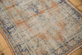 Faded apricot, blue, and ivory distressed Oushak rug with worn pile texture.