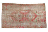Distressed vintage Oushak rug featuring faded raspberry, blush, and neutral geometric medallions, 3' x 5'3