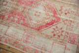 Vintage distressed Oushak rug detail: worn pink and sand geometric patterns.