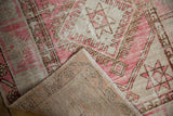 Distressed pink and brown Oushak rug pile, revealing its hand-knotted foundation and fringe.