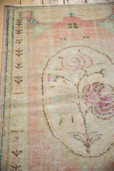 Distressed vintage Oushak rug detail: rose field, visible foundation wear, plant border.