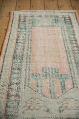 Distressed Oushak runner detail: worn pile, knot heads, faint foundation, pale rose, and teal.