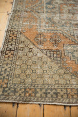 Distressed vintage Oushak rug corner, pale orange and beige with geometric border.
