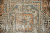 Distressed Oushak rug detail: worn pile revealing foundation, with muted orange, beige, and slate blue.