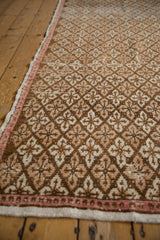 Distressed Oushak runner's repeating coffee brown and ivory floral patterns and blush selvage.