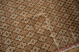 Coffee brown and ivory floral lattice pattern on a vintage Oushak rug with abrashes.