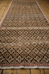 Distressed Oushak runner's repeating floral lattice pattern with coffee brown, charcoal, and ivory tones.