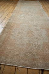 Distressed vintage Oushak runner with muted beige and sand tones, showing worn texture.