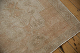 Distressed Oushak runner showing textured neutral pile with wear and finished selvage.