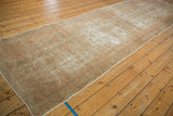 Vintage distressed Oushak runner showing overall fading in neutral ivory and sand.