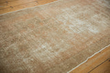 Distressed vintage Oushak rug texture with areas of wear and intact side selvage.