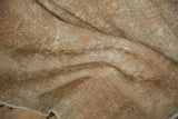 Textured surface of distressed Oushak runner pile with even wear and exposed foundation.