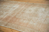 Distressed vintage Oushak runner's textured pile, with mostly even wear and ivory, sand tones.
