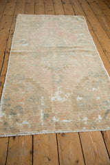Angled view of distressed Oushak rug pile, revealing pastel colors and foundation.