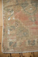 Vintage Distressed Oushak rug corner showing faded pastel pile, visible foundation, and secured fringe.