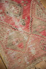 Distressed Oushak rug detail, highlighting faded red, sand tones, and visible foundation.