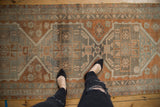 Distressed Oushak runner displaying geometric medallion outlines with copper, charcoal, and silver hues.