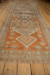 Distressed vintage Oushak runner with copper, oxidized silver, and charcoal central medallion.